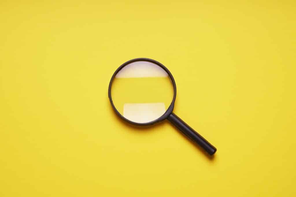 loupe or magnifying glass as internet search symbol. yellow background with copy space